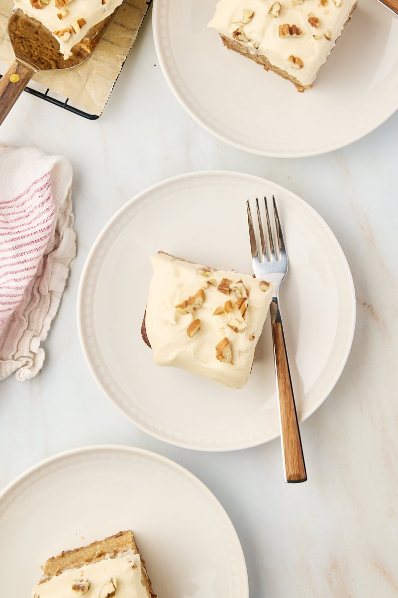 overhead view of slices of applesauce cake on white and beige plates