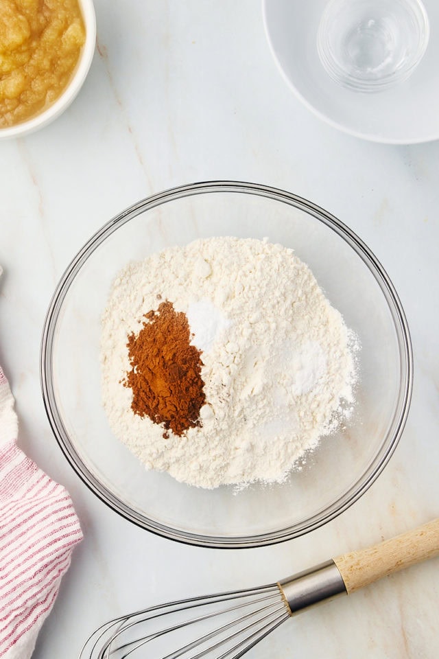 overhead view of dry ingredients for applesauce cake in a glass mixing bowl