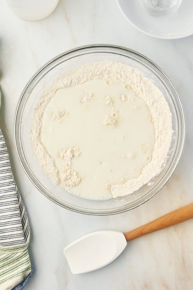 overhead view of buttermilk added to dry ingredients for butter swim biscuits