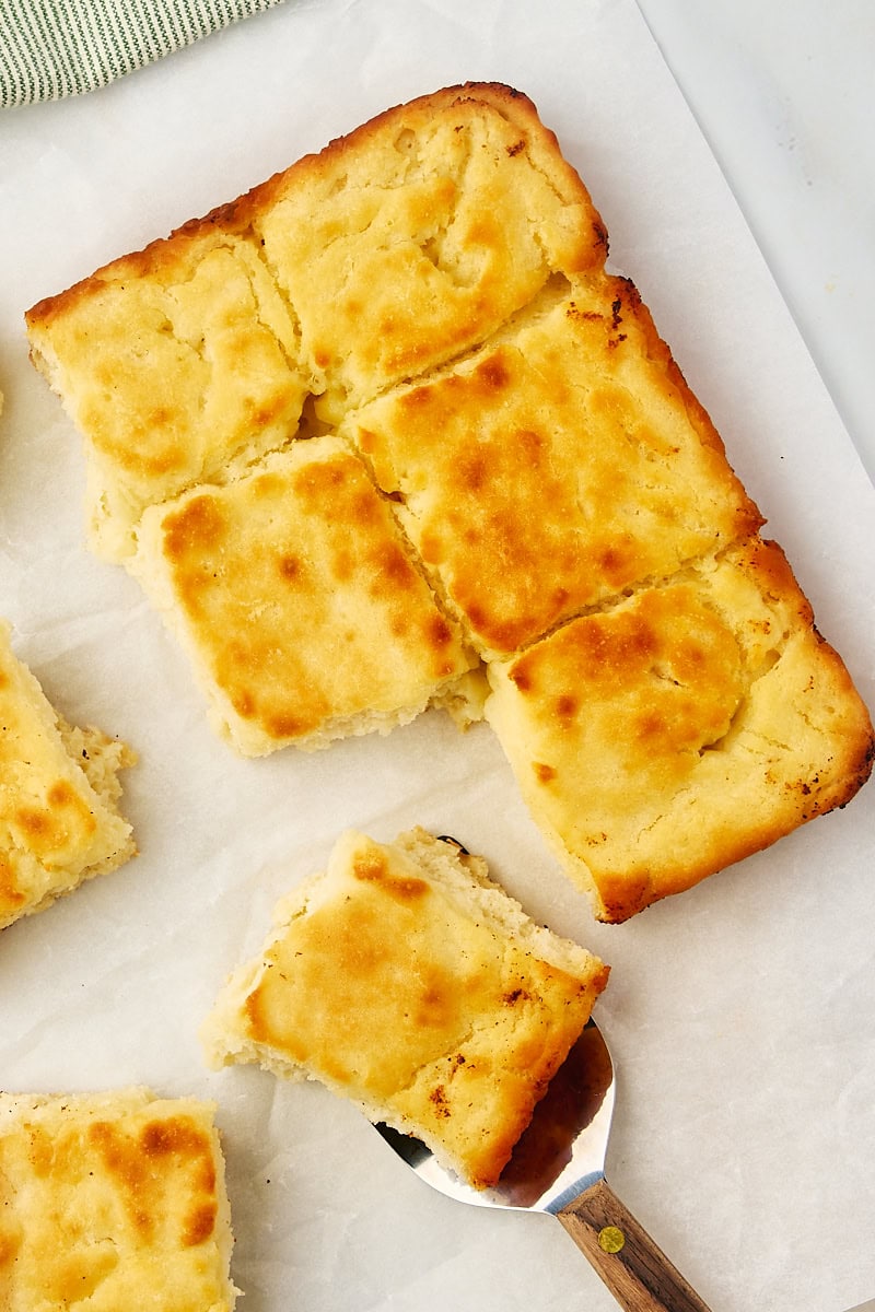 overhead view of partially pulled apart butter swim biscuits on parchment paper