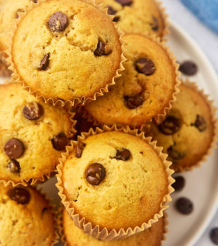 overhead view of chocolate chip muffins piled on a white plate