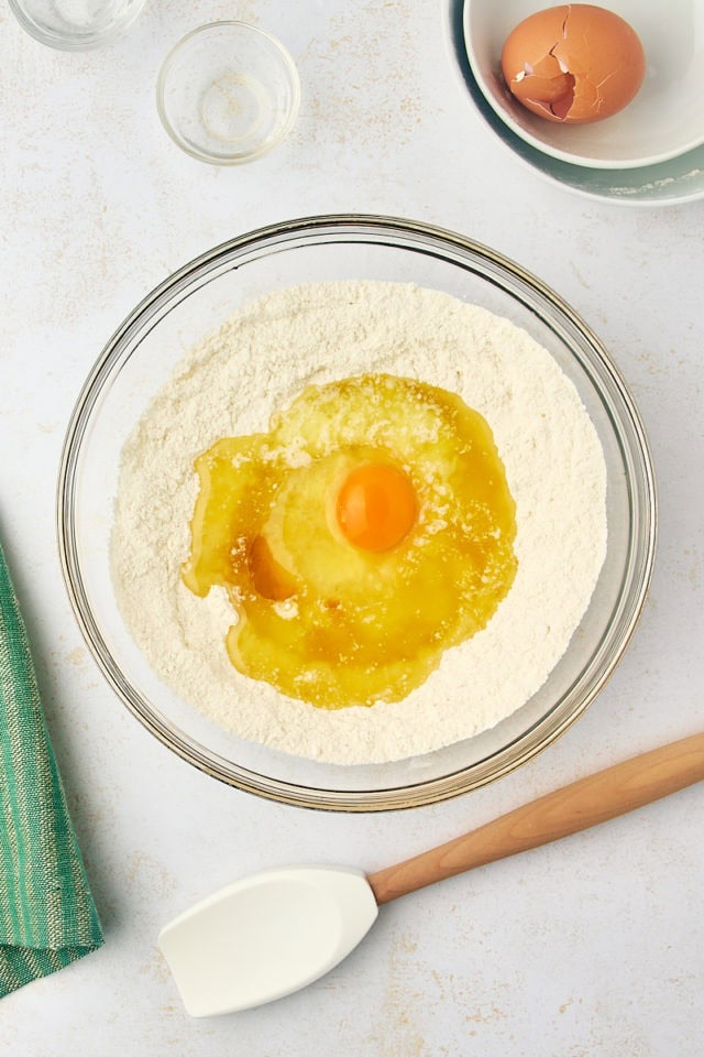 overhead view of melted butter, egg, and vanilla added to dry ingredients for gooey butter cake