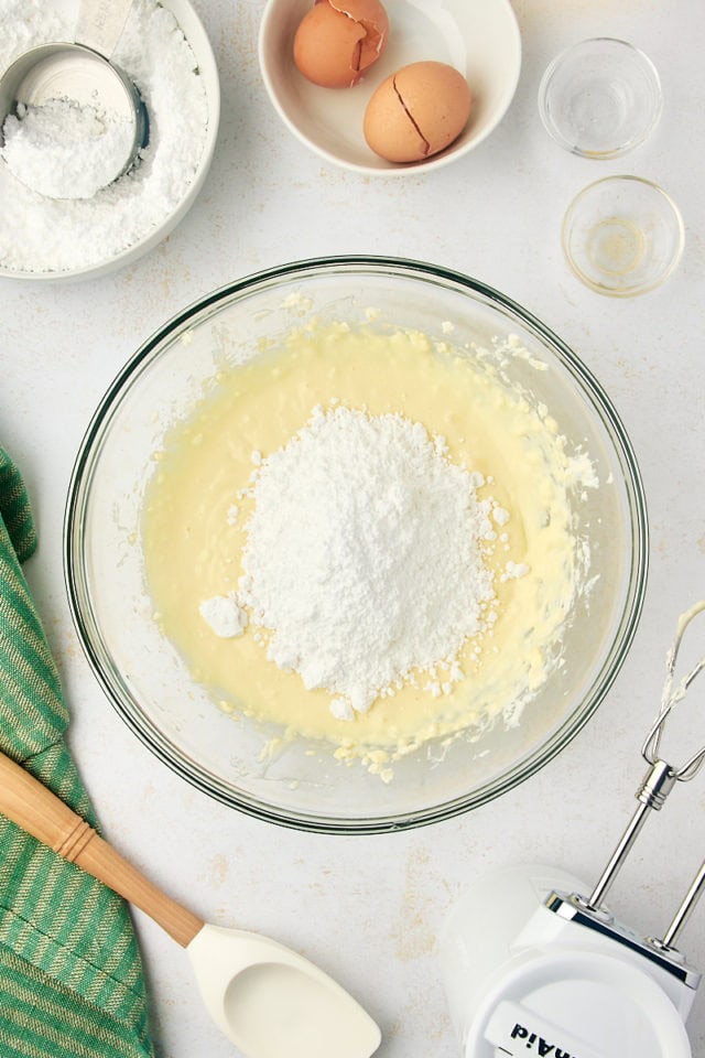 overhead view of confectioners' sugar added to cream cheese mixture for gooey butter cake