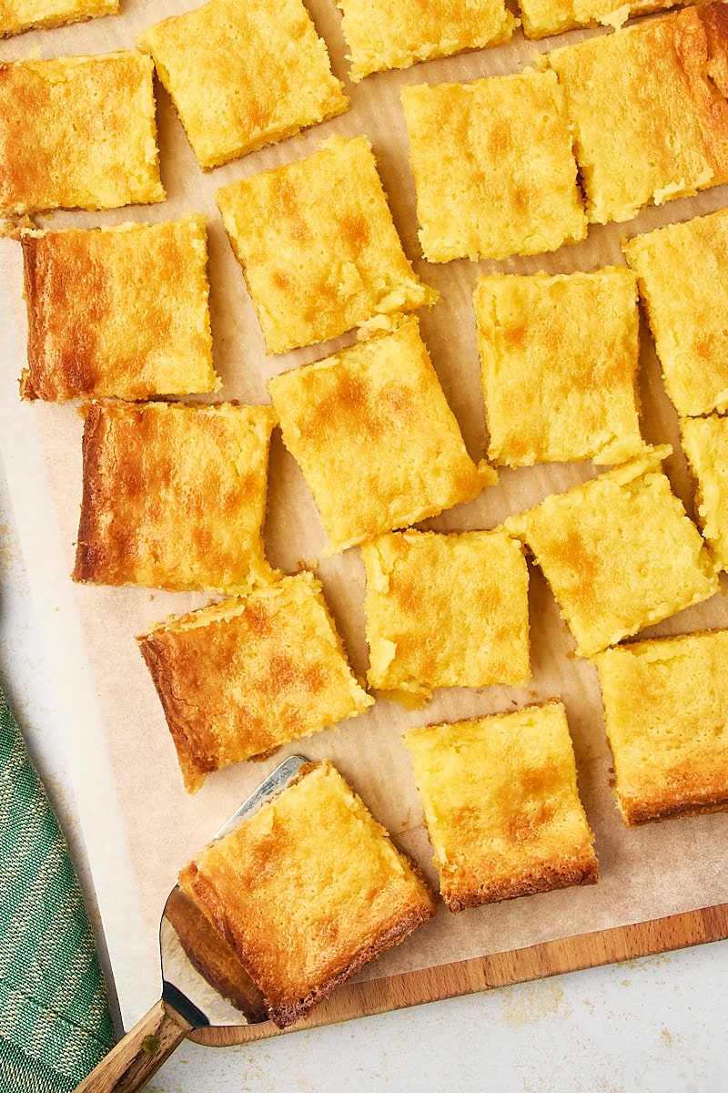 overhead view of sliced gooey butter cake on parchment paper