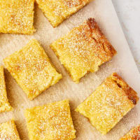 overhead view of slices of gooey butter cake dusted with confectioners' sugar