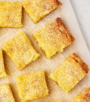 overhead view of slices of gooey butter cake dusted with confectioners' sugar