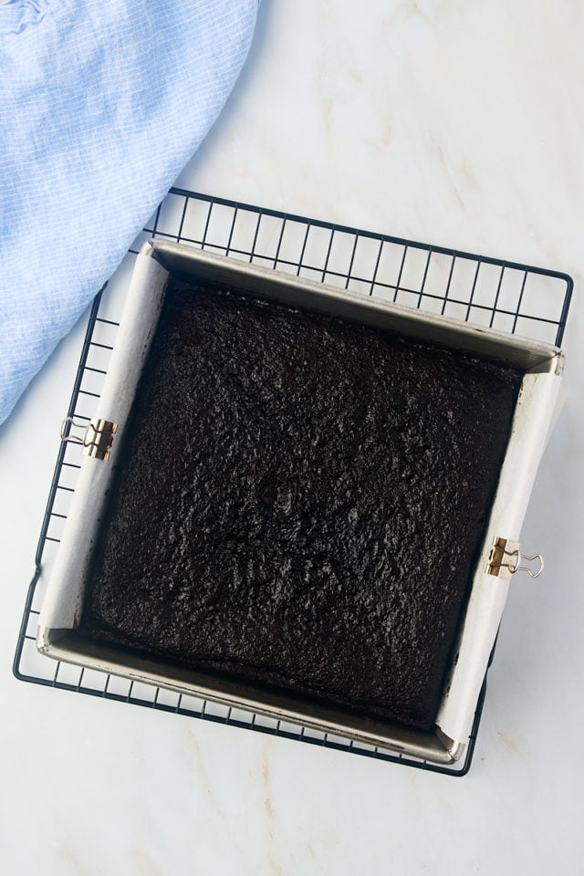 overhead view of freshly baked one-bowl chocolate cake in a square pan on a wire rack