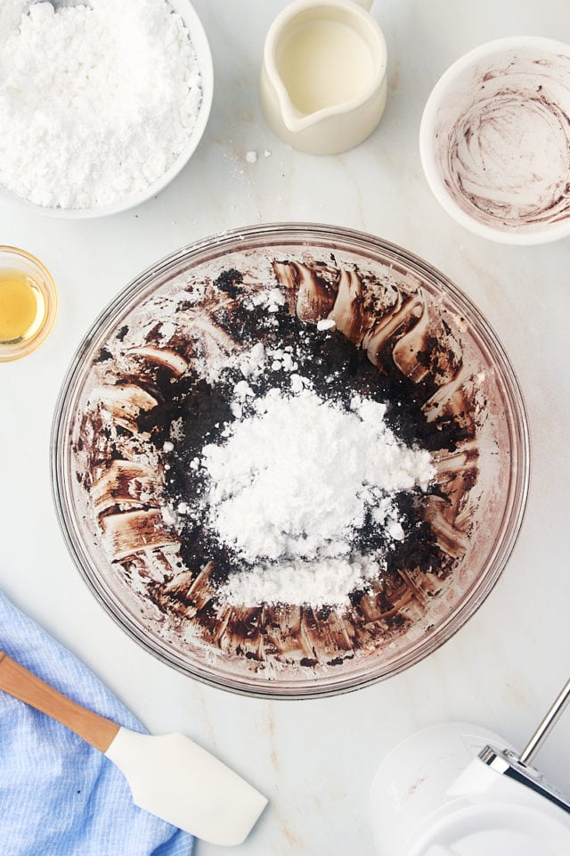 overhead view of confectioners' sugar added to frosting mixture