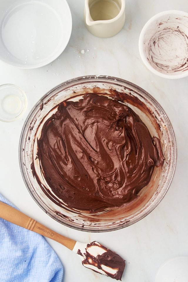 overhead view of chocolate frosting in a glass mixing bowl