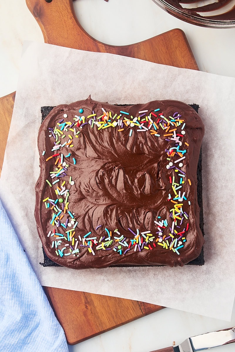 overhead view of frosted one-bowl chocolate cake topped with rainbow sprinkles