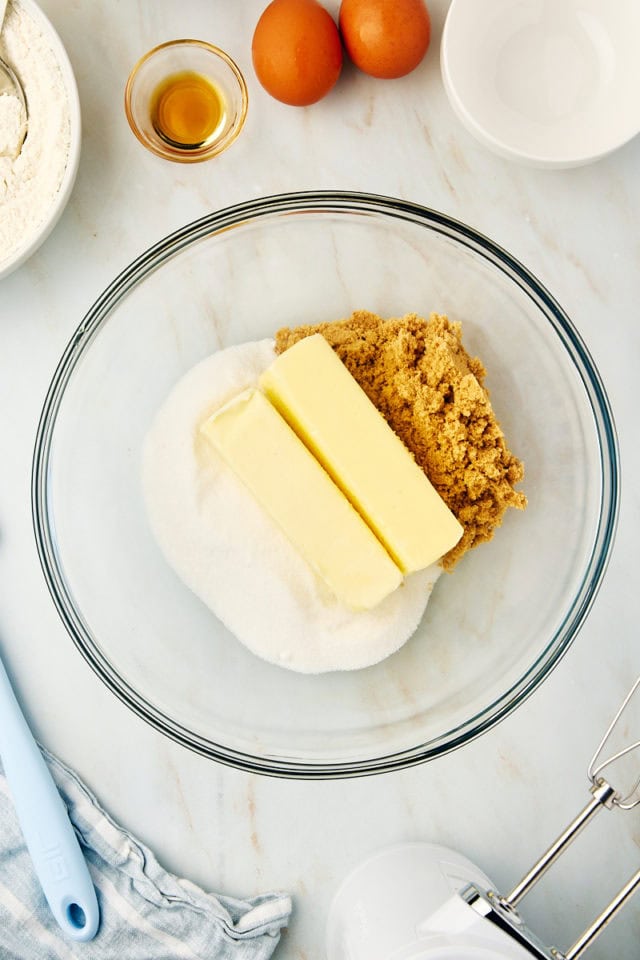 overhead view of butter, sugar, and brown sugar in a glass mixing bowl