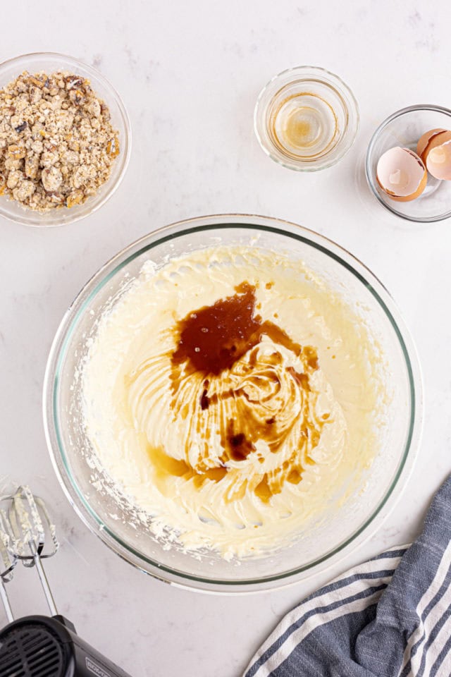 overhead view of vanilla and lemon juice added to cheesecake mixture