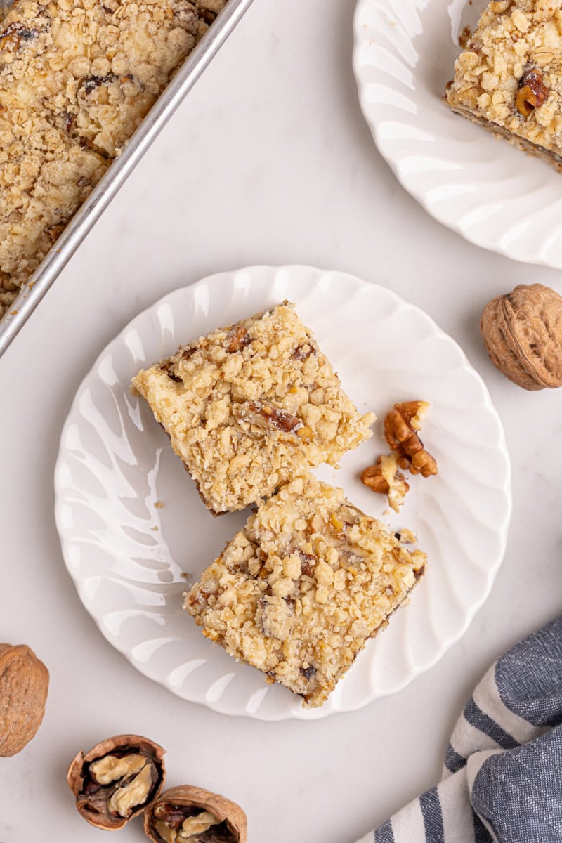 apple butter cream cheese oat bars on a white plate with more bars surrounding