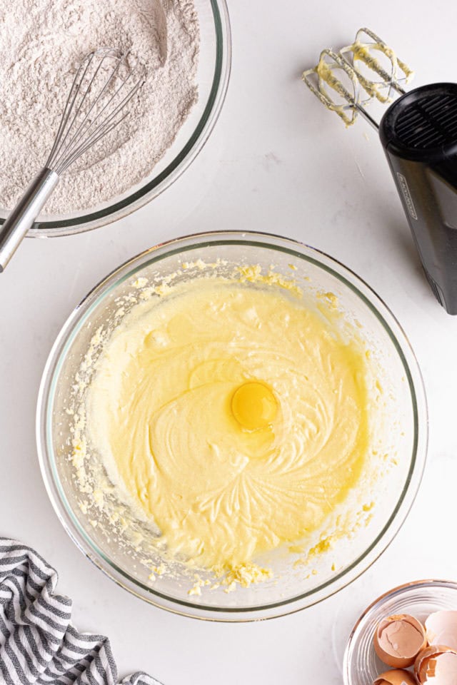 overhead view of egg added to creamed butter and sugar