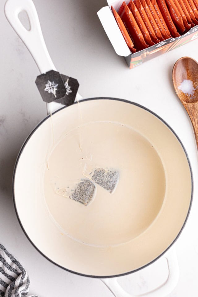 overhead view of black chai tea steeping in milk in a saucepan