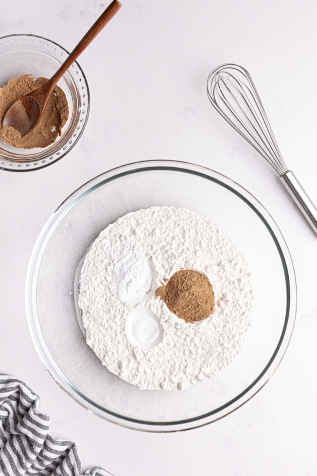 overhead view of flour, baking powder, salt, and spices in a glass mixing bowl