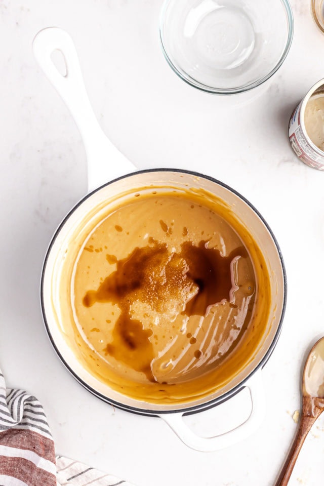 overhead view of vanilla and salt added to freshly cooked caramel