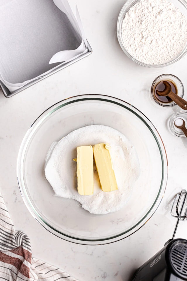 overhead view of butter and sugar in a glass mixing bowl