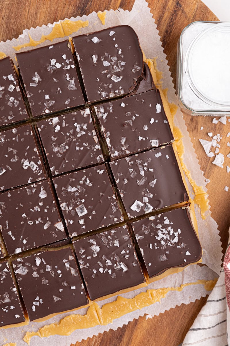 overhead view of millionaire shortbread bars cut into bars on a wooden cutting board