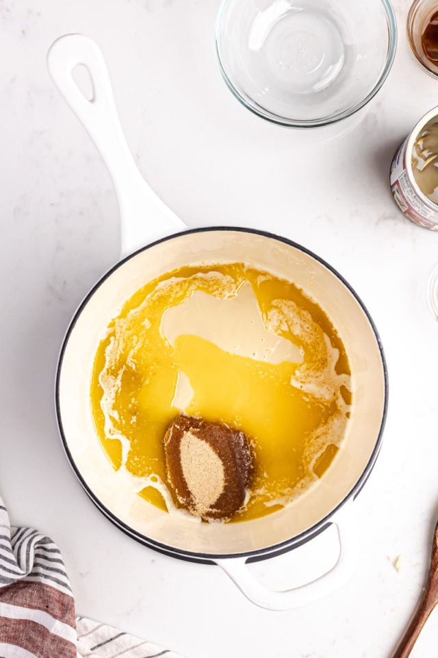 overhead view of brown sugar, condensed milk, and corn syrup added to melted butter in a saucepan