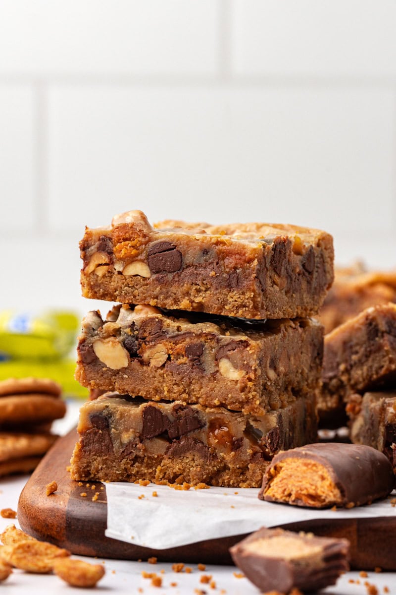 stack of three peanut butter candy bar squares on a wooden board