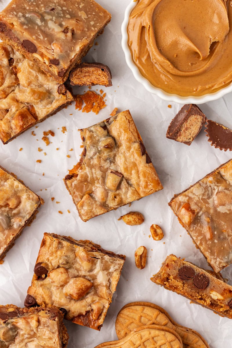 overhead view of a peanut butter candy bar square with a bite missing, surrounded by more bars