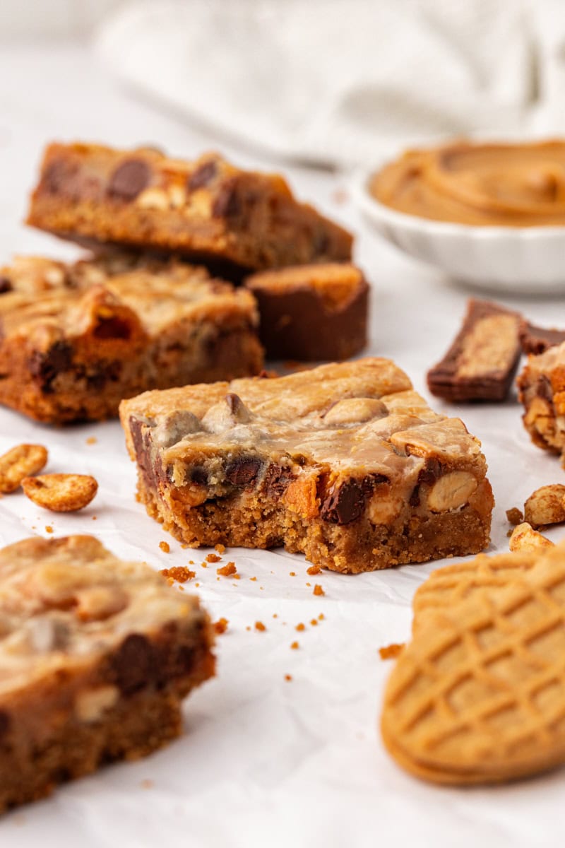 a peanut butter candy bar square with a bite missing surrounded by more bars