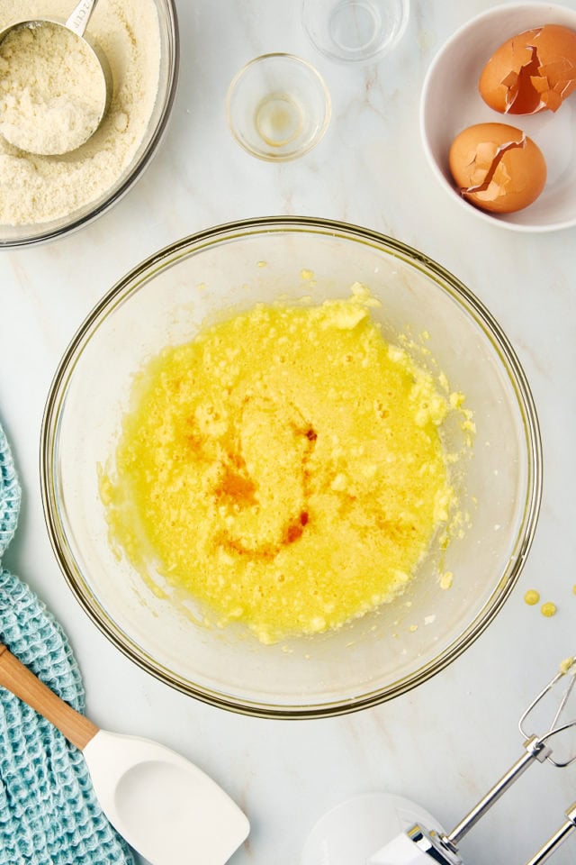 overhead view of vanilla and almond extracts added to cake batter