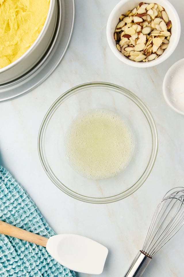 overhead view of whisked egg white in a glass bowl