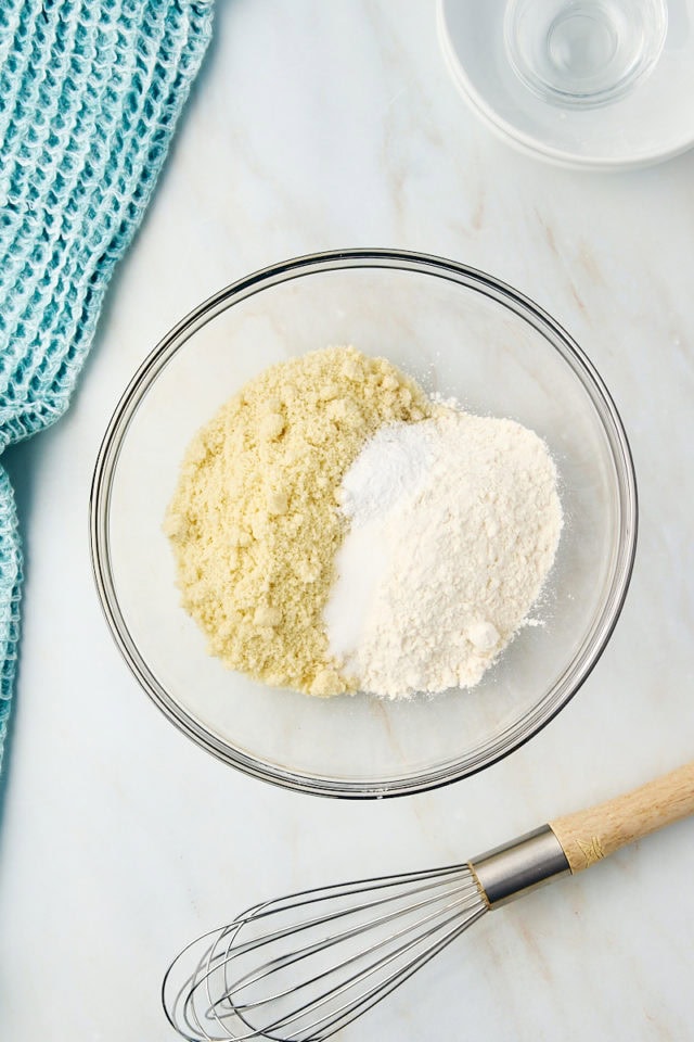 overhead view of almond flour, all-purpose flour, salt, and baking powder in a glass mixing bowl