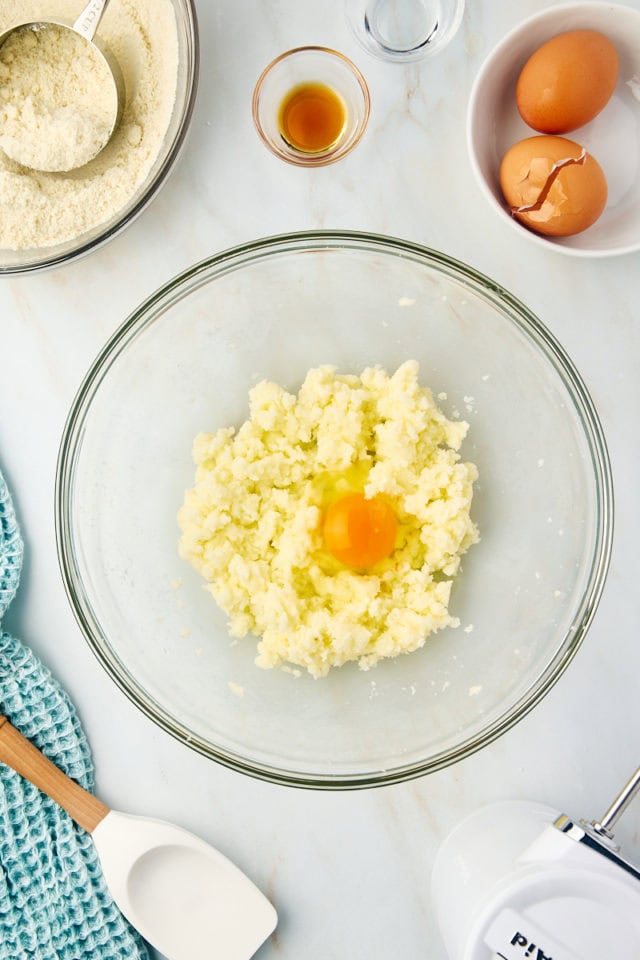 overhead view of egg added to creamed butter and sugar