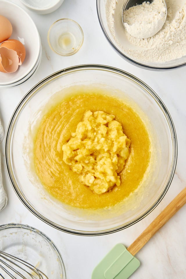 overhead view of mashed bananas added to quick bread batter