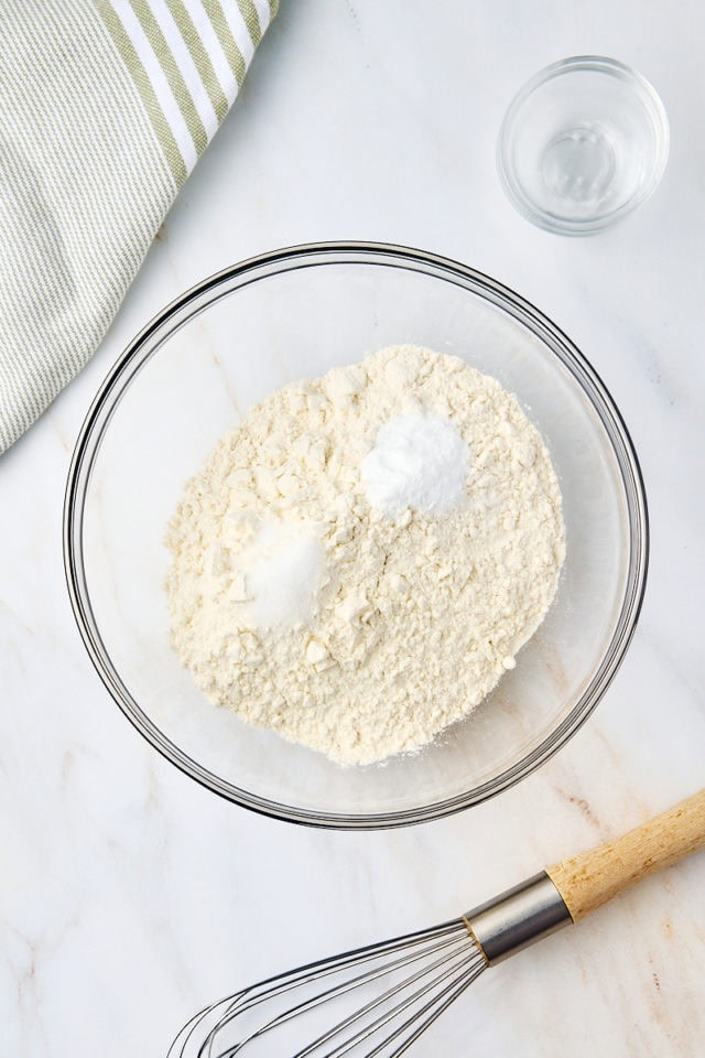 overhead view of flour, baking soda, and salt in a glass mixing bowl