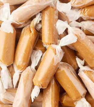 close-up of homemade soft caramels wrapped in wax paper