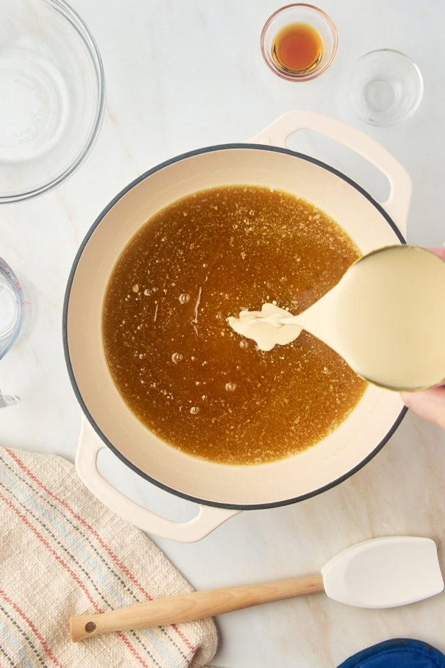 overhead view of evaporated milk slowly being added to remaining caramel mixture