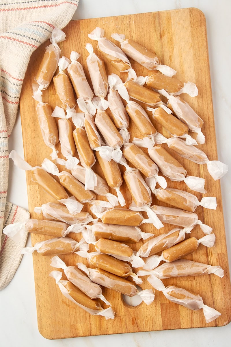 overhead view of homemade caramels wrapped in wax paper