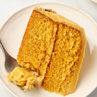 a slice of dulce de leche cake on a plate with a bite on a fork