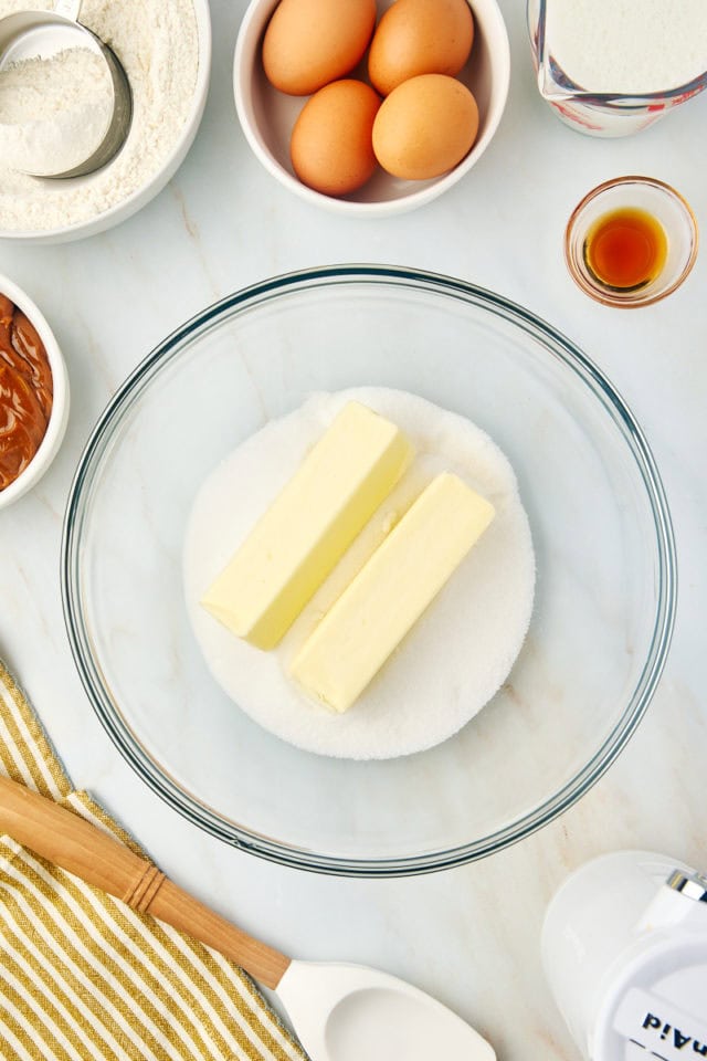 overhead view of butter and sugar in a glass mixing bowl