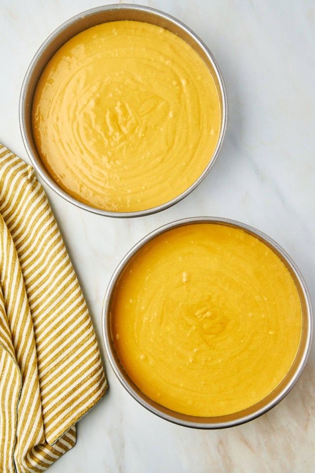 overhead view of dulce de leche cake batter in two round cake pans