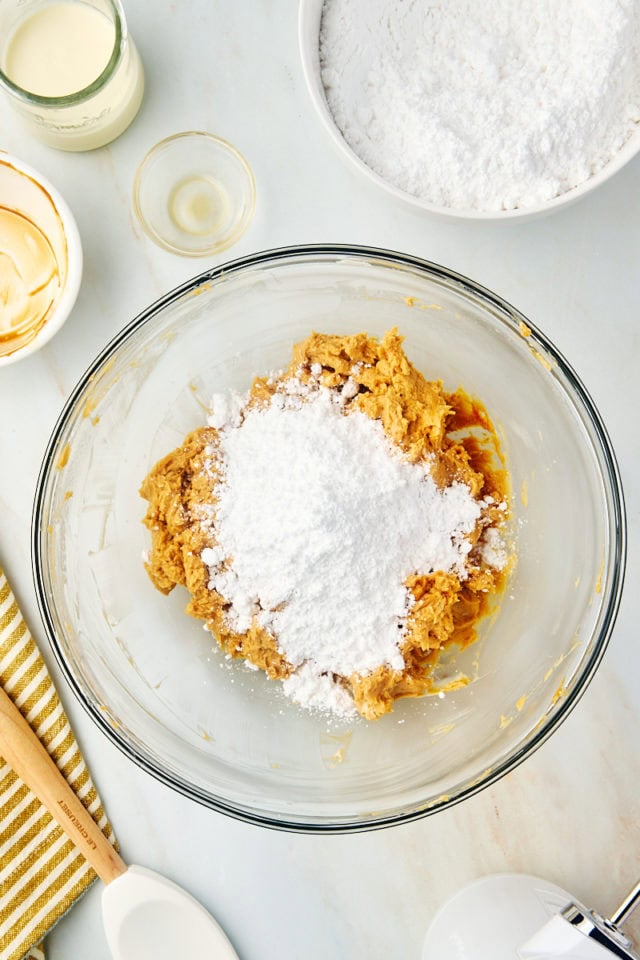 overhead view of confectioners' sugar added to dulce de leche frosting mixture