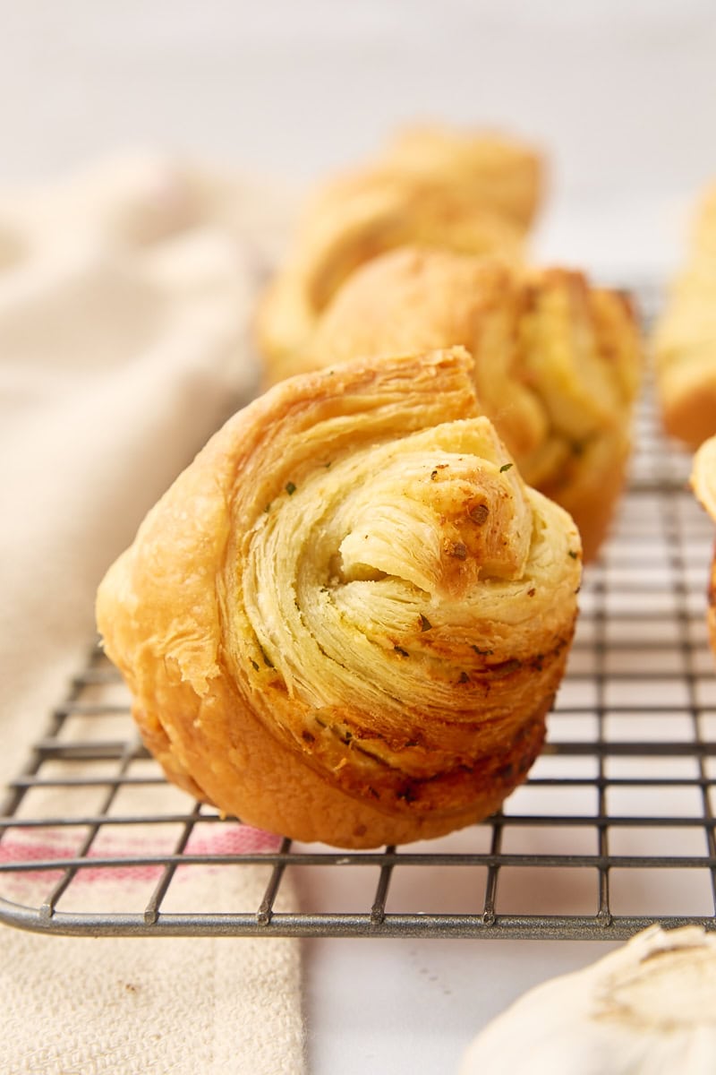 a garlic butter cruffin on a wire rack along with more cruffins