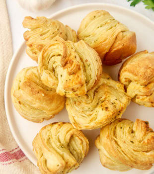 overhead view of garlic butter cruffins on a large white plate