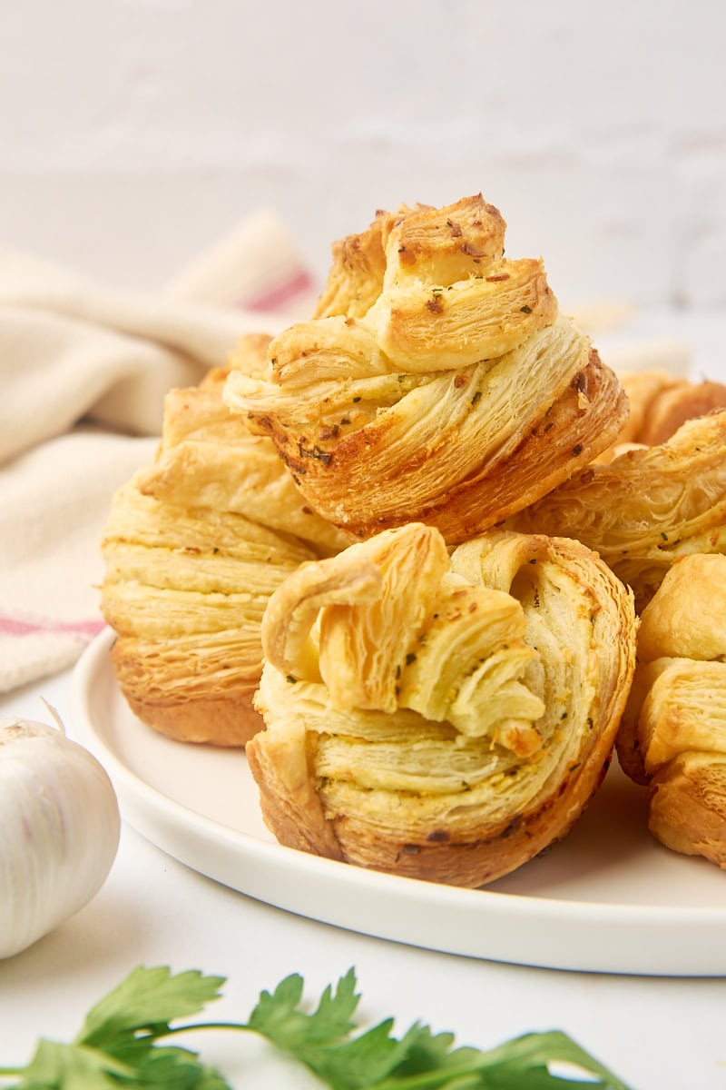 garlic butter cruffins piled on a large white plate