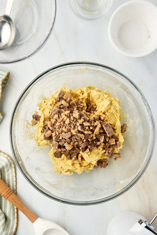 Toffee bits added to bowl of cookie dough