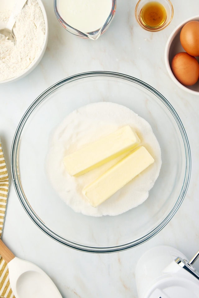 overhead view of butter and sugar in a glass mixing bowl