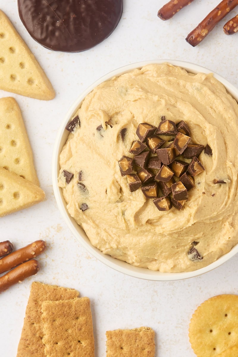 overhead view of peanut butter cup dip with pretzels, cookies, and crackers scattered around the bowl