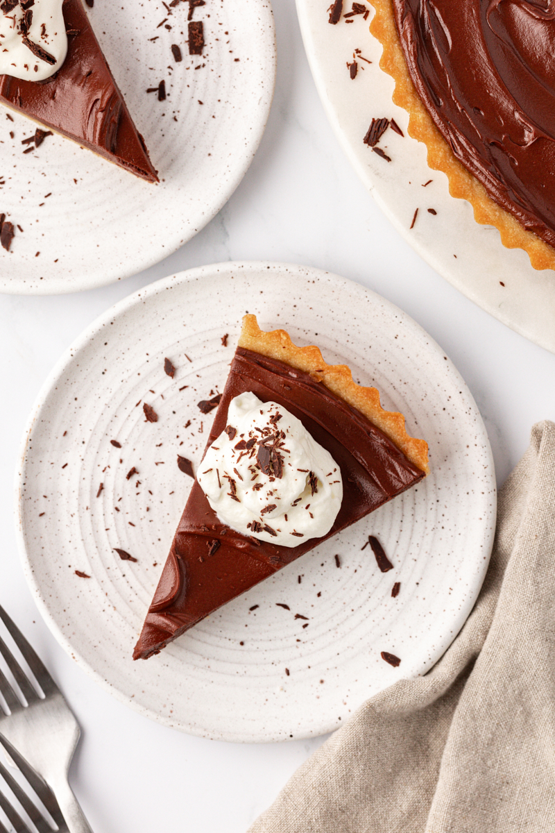 overhead view of a slice of chocolate mascarpone tart on a white plate