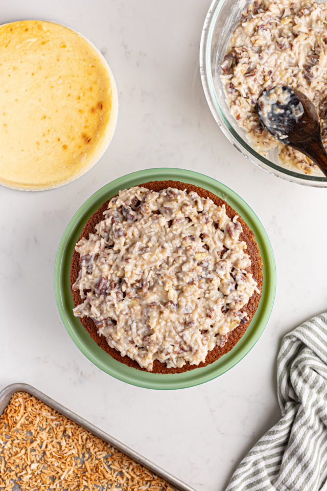 Adding frosting to first layer of German chocolate cheesecake