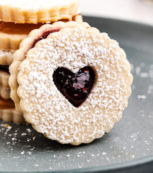 a Linzer cookie leaned against a stack of more cookies