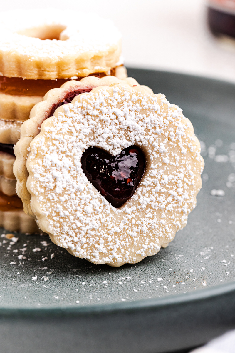 a Linzer cookie leaned against a stack of more cookies